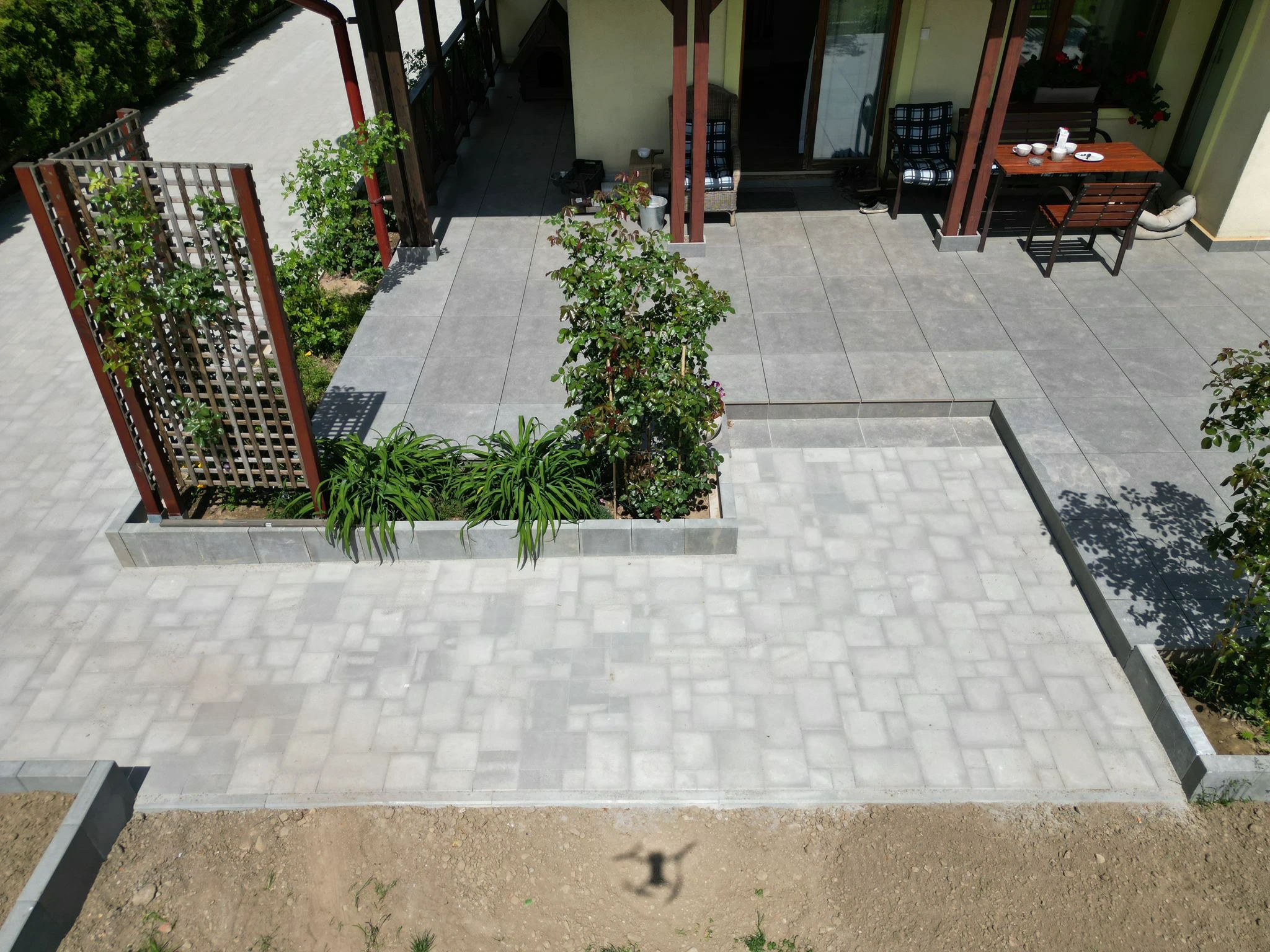 Tarasy z kostki brukowej – taras z betonowym obrzeżem i rabatą z kratownicą na pnącza