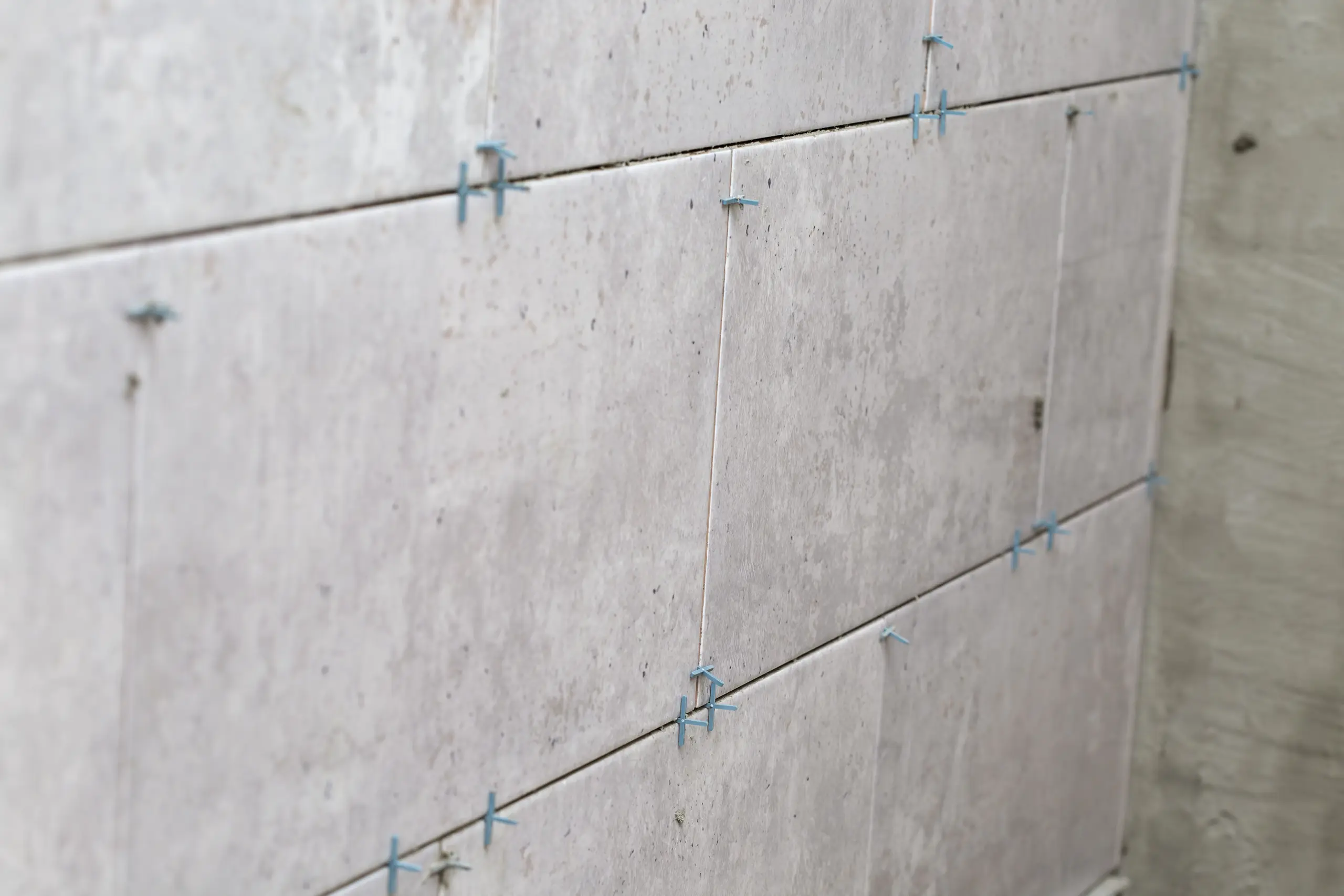 Beton architektoniczny – szare płyty elewacyjne układane z krzyżykami dystansowymi